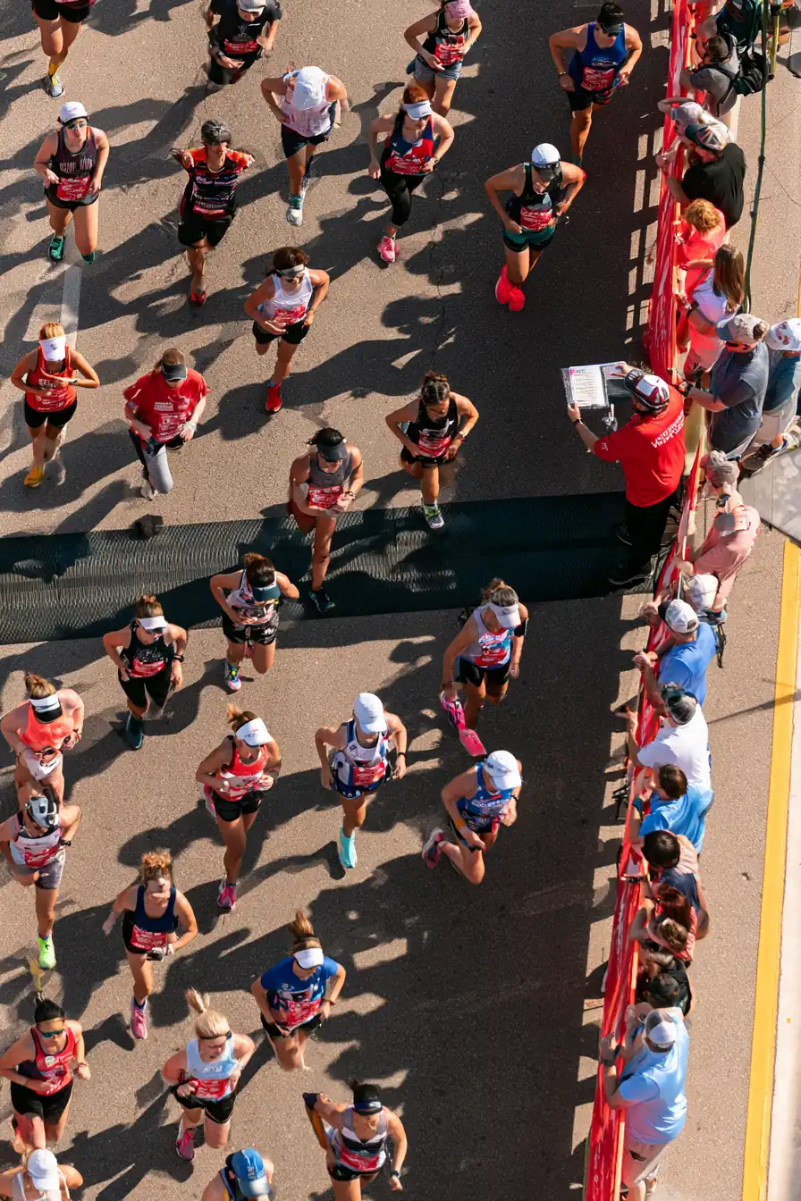 Marathon volunteer checking runners through an orderly start gate